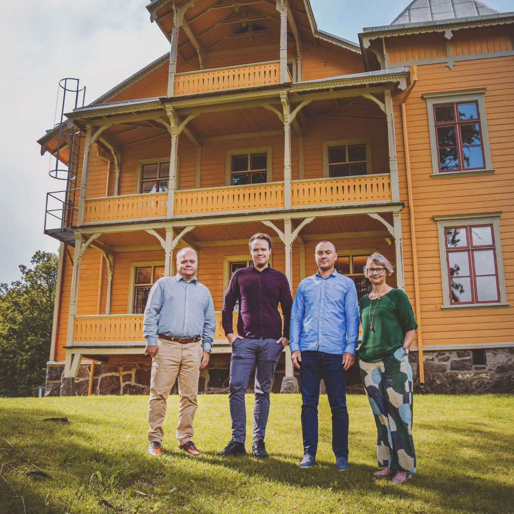 Personalen framför ett dekorerat gult trähus